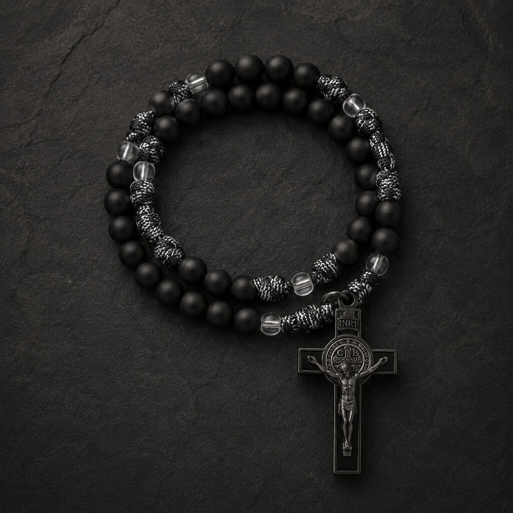 Top view of the Black Monk five-decade rosary with black beads, woven knots, clear accents, and a St. Benedict crucifix.