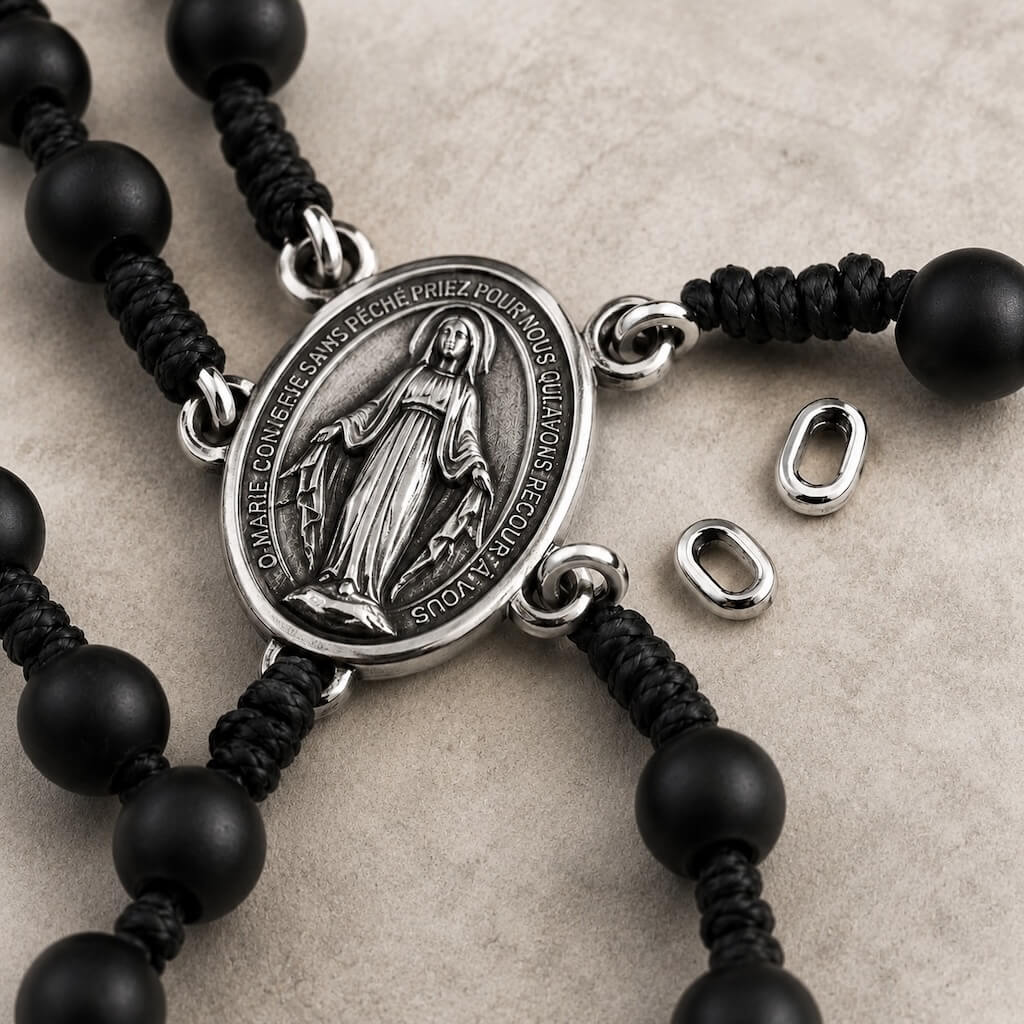 Close-up of the Miraculous Medal centerpiece, knotted cord, and replaceable connector links on the Compact Everyday Rosary.