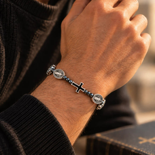 Saint Benedict bracelet with black cross and silver medals worn on a man's wrist