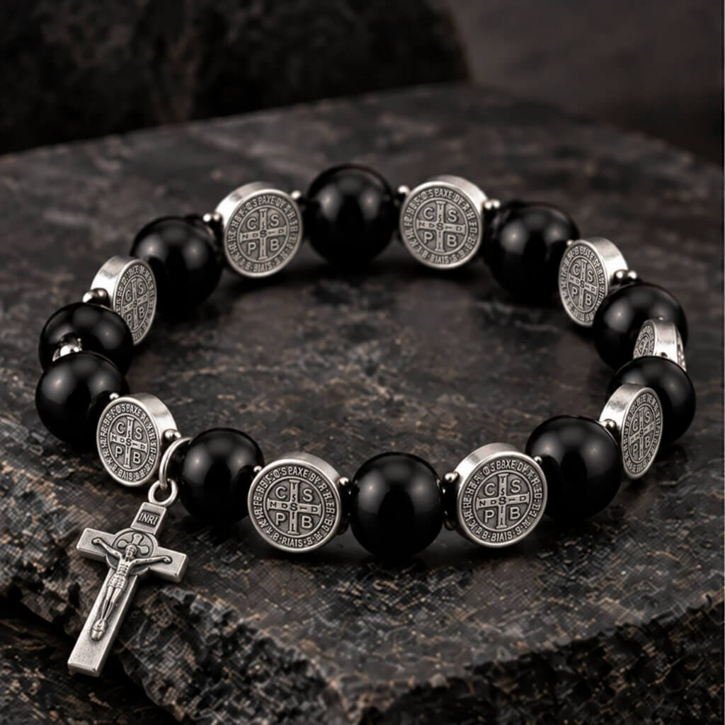 Black wood St. Benedict bracelet with silver-tone medals and crucifix displayed on dark stone