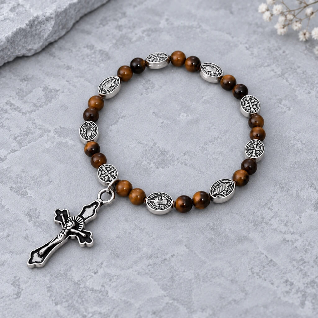 Tiger eye Catholic bracelet with silver medals and crucifix on cool gray stone background