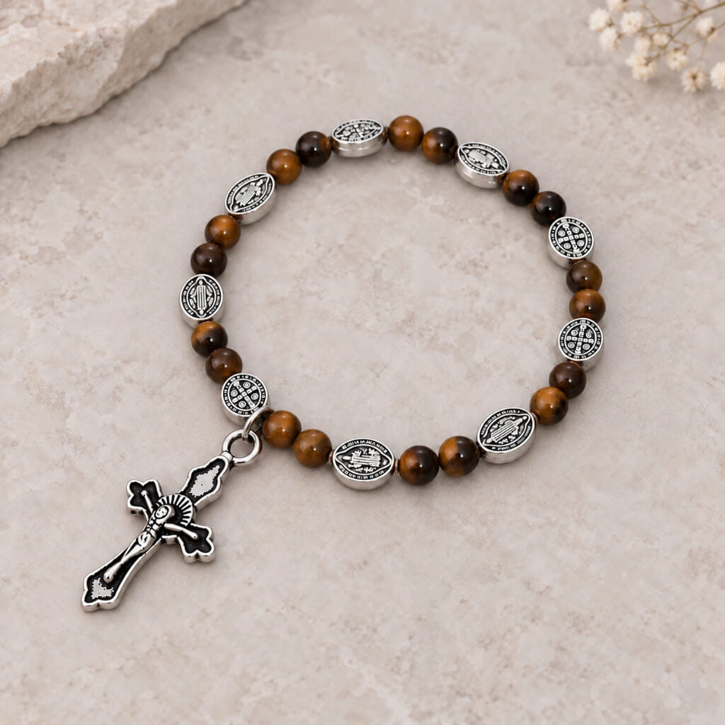 Tiger eye Catholic bracelet with silver religious medals and crucifix on warm beige stone
