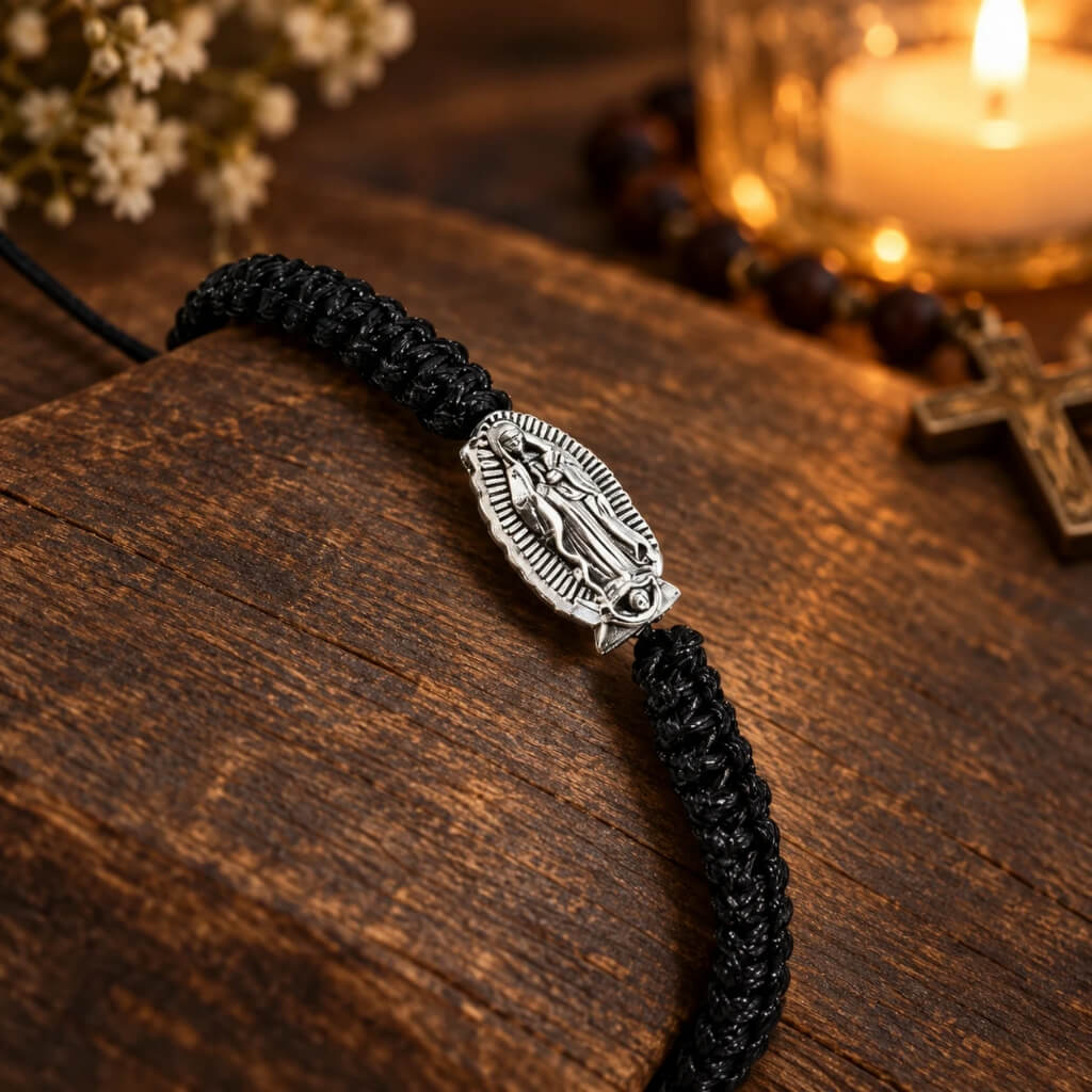 Virgin Mary black cord bracelet displayed on warm wood with Catholic devotional setting